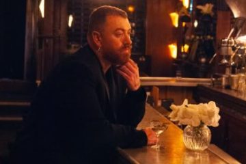 Sam Smith aguarda seu par no bar, acompanhado de um dry martini, em prévia do clipe de “My Guy